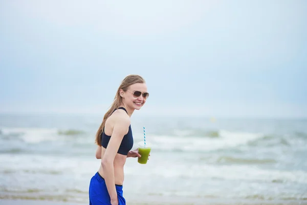 Runner girl drinking green vegetable smoothie — Stock Photo, Image