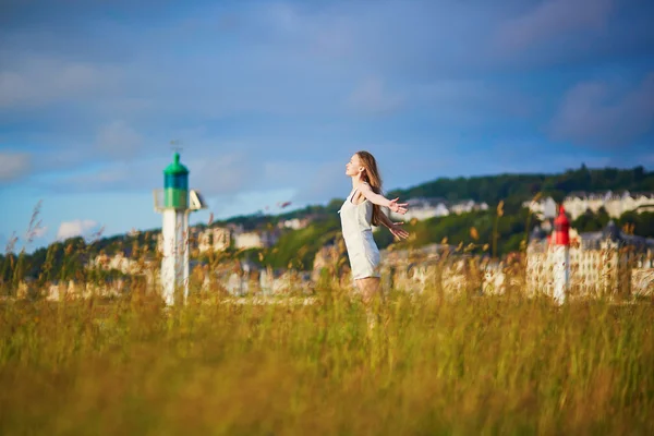 Frau bei Sonnenuntergang auf einer Wiese in der Nähe des Leuchtturms in Deaville — Stockfoto