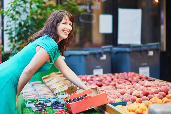 Franse vrouw kiezen vruchten op de markt — Stockfoto