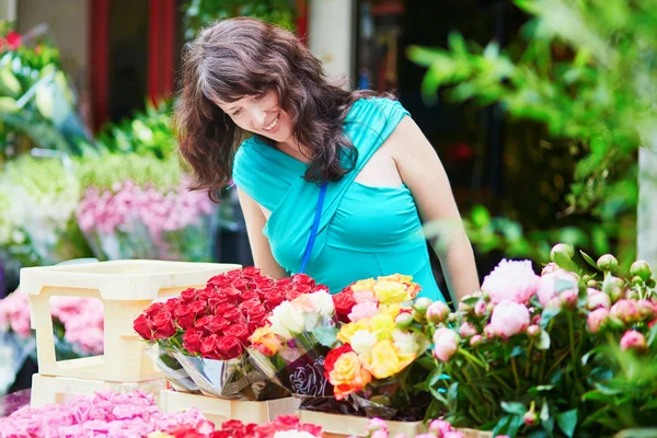 Французская женщина выбирает цветы на рынке — стоковое фото