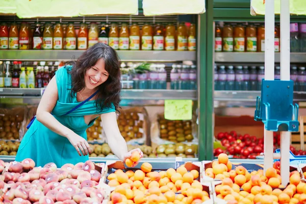 Французская женщина выбирает фрукты на рынке — стоковое фото