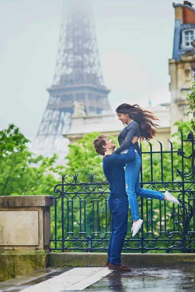 Feliz pareja joven frente a la Torre Eiffel — Foto de Stock