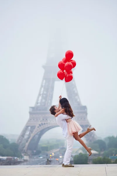Romantický pár s červenými balóny spolu v Paříži — Stock fotografie