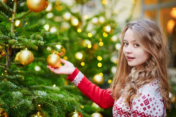 Giovane donna su una strada di Parigi decorata per Natale — Foto Stock