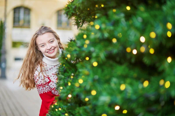 Junge Frau auf einer weihnachtlich geschmückten Straße in Paris — Stockfoto