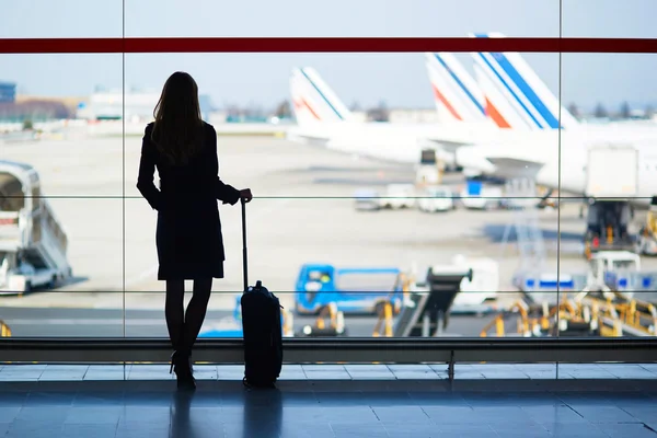Jonge vrouwelijke reiziger in internationale luchthaven Stockafbeelding