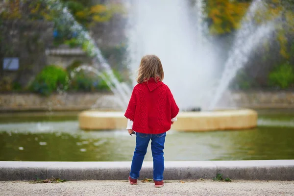 秋の公園を歩く赤いポンチョの愛らしい幼児の女の子 フランスで秋の日を楽しんで幸せな子供 子供のための屋外活動 — ストック写真