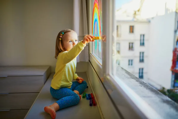 Förtjusande Liten Flicka Som Ritar Regnbåge Fönsterglas Som Tecken Hopp — Stockfoto