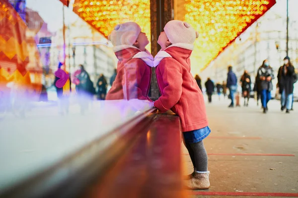 クリスマスのために飾られた大型デパートの窓ガラスを見て幼児の女の子 フランスのホリデーシーズンを楽しむ子供 — ストック写真