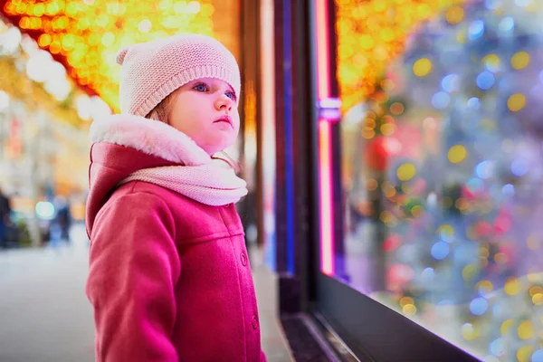 クリスマスのために飾られた大型デパートの窓ガラスを見て幼児の女の子 フランスのホリデーシーズンを楽しむ子供 — ストック写真