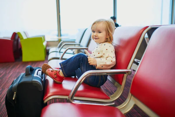 飛行機で旅行する愛らしい小さな幼児の女の子 子供たちはゲートに座ってフライトを待っています 子供と一緒に海外旅行 同伴しない未成年の概念 — ストック写真