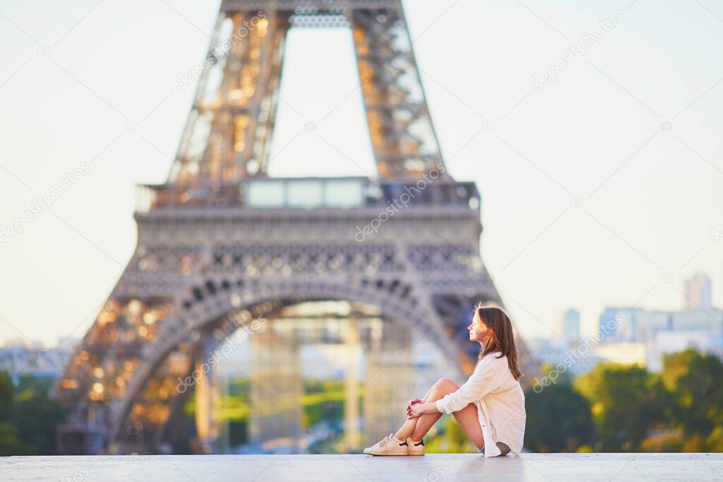 Beautiful young woman in Paris near the Eiffel tower at morning. Parisian girl on Trocadero view point. Tourist enjoying vacation in France
