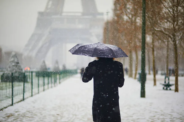 パリのエッフェル塔を大雪の日に通り過ぎる人々 フランスで異常な天気予報 — ストック写真