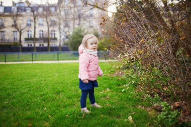 Bir bahar ya da sonbahar günü Paris parkında küçük sevimli bir kız. Çocuklar için açık hava aktiviteleri