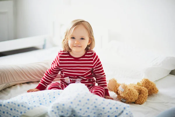 Glad Liten Flicka Randig Röd Och Vit Pyjamas Sitter Sängen — Stockfoto