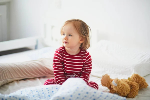 Glad Liten Flicka Randig Röd Och Vit Pyjamas Sitter Sängen — Stockfoto
