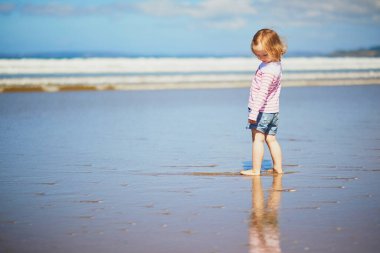 Brittany, Fransa 'nın Atlantik kıyısındaki kumsalda küçük sevimli bir kız. Küçük çocuk deniz ya da okyanus kenarında tatilin tadını çıkarıyor. Çocuklarla seyahat etmek.