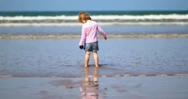 Brittany, Fransa 'nın Atlantik kıyısındaki kumsalda küçük sevimli bir kız. Küçük çocuk deniz ya da okyanus kenarında tatilin tadını çıkarıyor. Çocuklarla seyahat etmek.