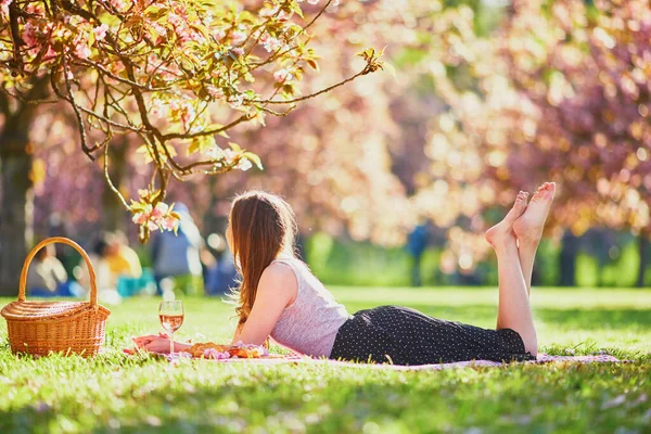 Mooie Jonge Vrouw Picknicken Zonnige Lentedag Park Tijdens Kersenbloesem Seizoen — Stockfoto