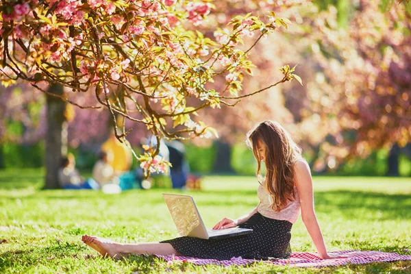 Hermosa Joven Que Trabaja Computadora Portátil Parque Durante Temporada Flores —  Fotos de Stock