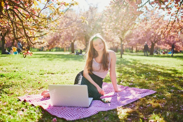 Hermosa Joven Que Trabaja Computadora Portátil Parque Durante Temporada Flores —  Fotos de Stock