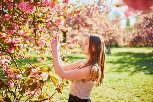 Hermosa Chica Jardín Flores Cerezo Día Primavera Tomando Fotos Grabando —  Fotos de Stock