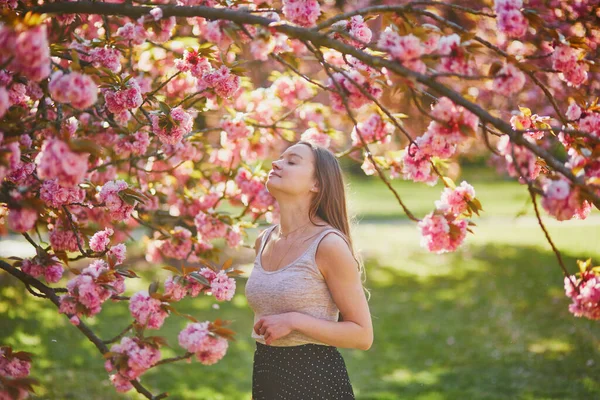 春の日に桜の庭で美しい女の子 フランス パリ近郊の有名なスコー公園の若い女性 — ストック写真