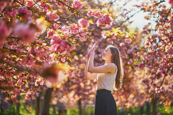 Hermosa Chica Jardín Flores Cerezo Día Primavera Tomando Fotos Grabando —  Fotos de Stock