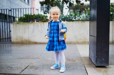 Komik sırt çantalı sevimli kız kreşe, anaokuluna ya da okula gitmeye hazır. Okul konseptinin ilk günü