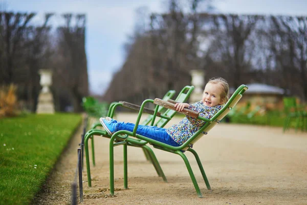 幸せな陽気な幼児の女の子座っています上の緑の椅子でチュイルリーパリ フランス — ストック写真