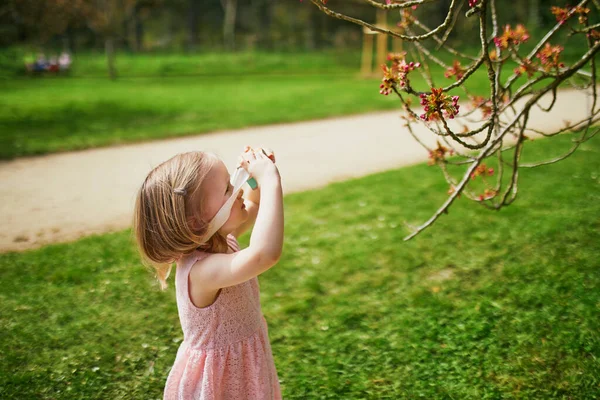在法国巴黎附近的Sceaux公园里 身穿粉色衣服的可爱的3岁小女孩 享受着阳光灿烂的春日 还在玩木制摄影相机 — 图库照片