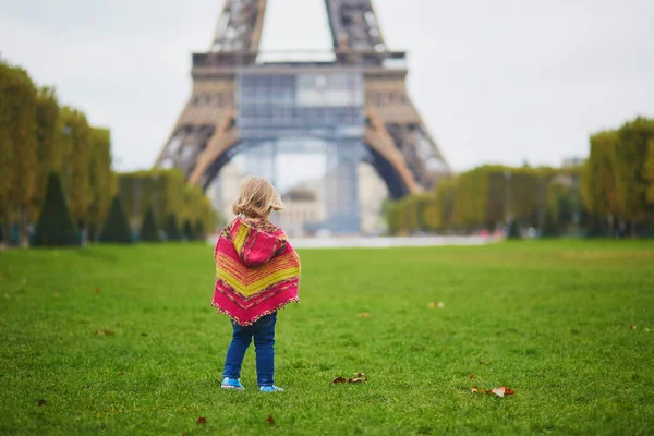 フランスのパリで秋の日にエッフェル塔の近くの愛らしい幼児の女の子 秋を屋外で楽しむ子供 子供のためのスタイリッシュかつ快適な秋の服 — ストック写真