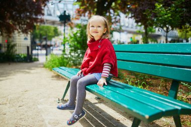 Paris, Fransa 'da bir sokakta bankta oturan üç yaşındaki sevimli bir kız.