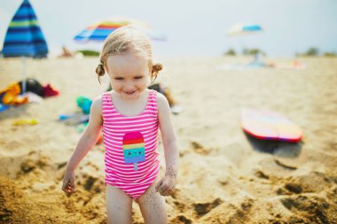 Mutlu küçük kız Fransa 'nın Akdeniz sahillerinde eğleniyor. Neşeli çocuk denizde tatilin tadını çıkarıyor. Çocuklar için açık hava yaz etkinlikleri
