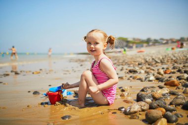 Brittany, Fransa 'nın Atlantik kıyısındaki kumsalda oynayan sevimli küçük kız. Küçük çocuk deniz ya da okyanus kenarında tatilin tadını çıkarıyor. Çocuklarla seyahat etmek.