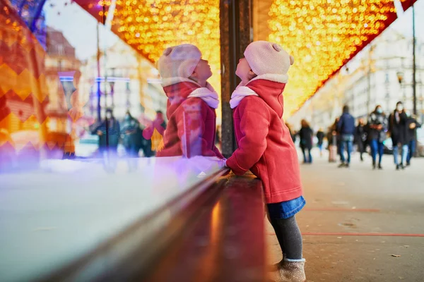 クリスマスのために飾られた大型デパートの窓ガラスを見て幼児の女の子 フランスのホリデーシーズンを楽しむ子供 — ストック写真