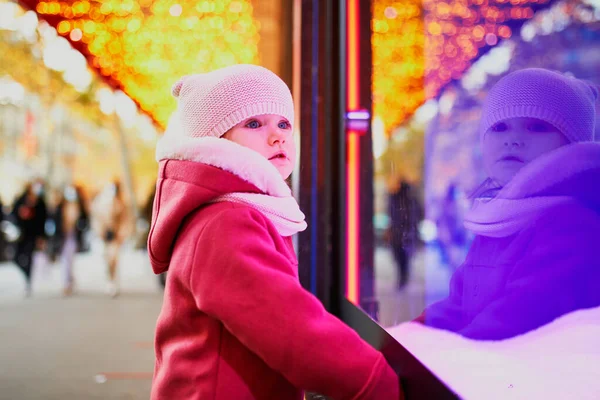 クリスマスのために飾られた大型デパートの窓ガラスを見て幼児の女の子 フランスのホリデーシーズンを楽しむ子供 — ストック写真