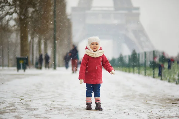 フランスで大雪の日にエッフェル塔の近くの愛らしい幼児の女の子 雪と遊ぶ幸せな子供 子供のための冬の活動 — ストック写真