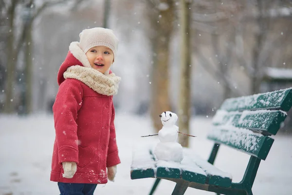 雪の多い日に雪だるまを作る愛らしい幼児の女の子 雪と遊ぶ幸せな子供 子供のための冬の活動 — ストック写真