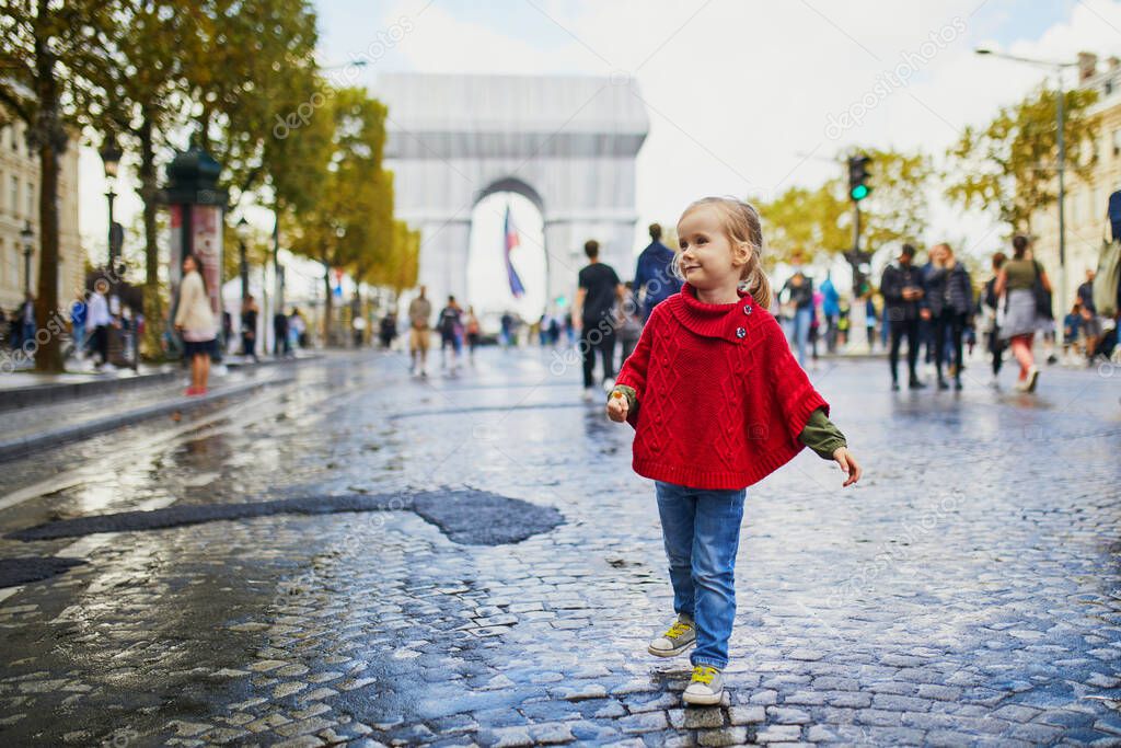 Happy preschooler girl walking in Champs-Elysees in Paris, France, during Day without cars (Journee sans voitures) event