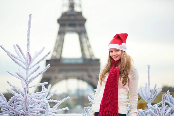 Девушка в шляпе Санта возле Эйфелевой башни — стоковое фото