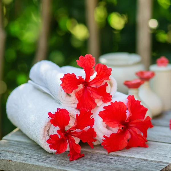 Spa setting with towels and red hibiscus flowers — Stock Photo, Image