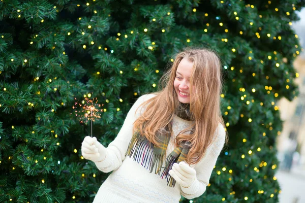 Mädchen mit Wunderkerze in der Nähe des Weihnachtsbaums — Stockfoto