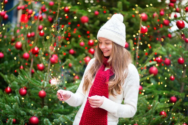 Parlak Noel ağacının yakınında bir maytap kızla — Stok fotoğraf