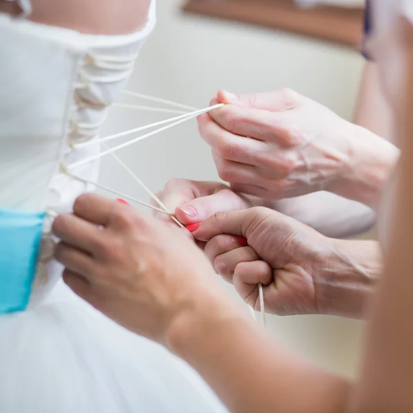 Damas de honor ayudando a la novia a ponerse su vestido —  Fotos de Stock