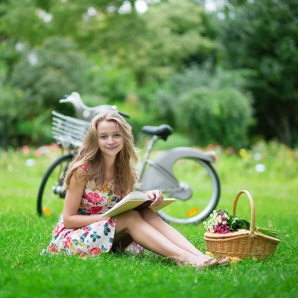 Mooi meisje het lezen van een boek in park — Stockfoto