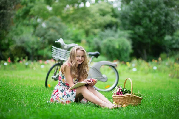 Belle jeune fille lisant un livre dans le parc — Photo