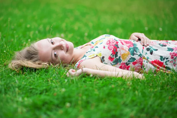 Beautiful young girl lying on the grass — Stock Photo, Image