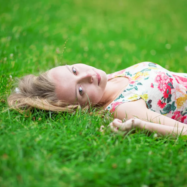 Beautiful young girl lying on the grass — Stock Photo, Image