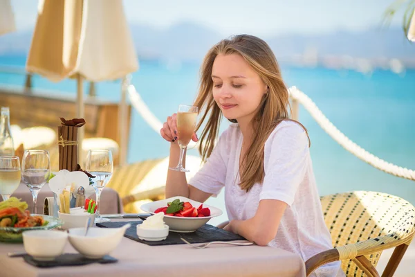 Kobieta jedzenie owoców w restauracji na plaży — Zdjęcie stockowe